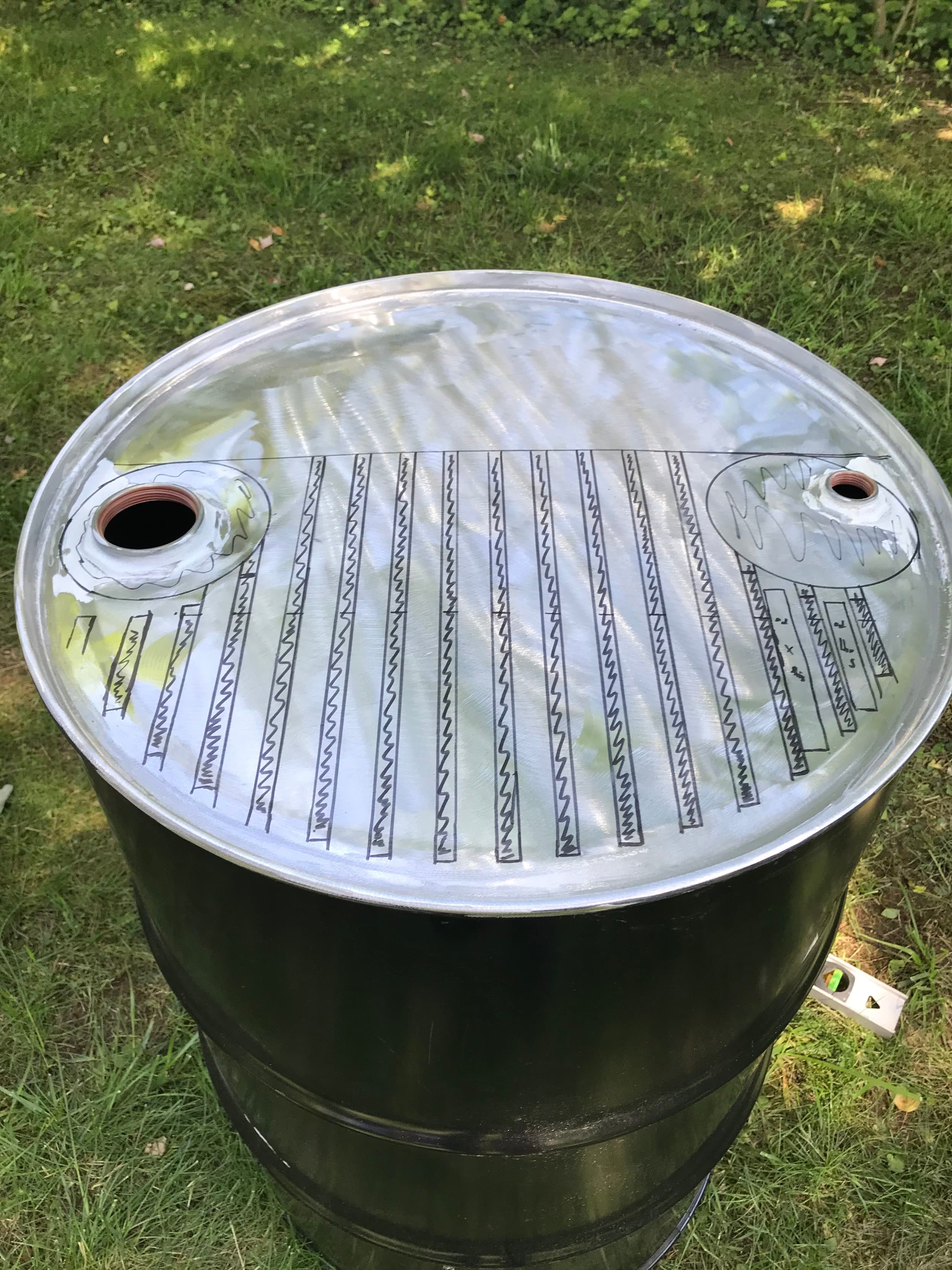 This was my first time wielding an angle grinder! I stripped the paint off the top of the drum and sketched out a design.